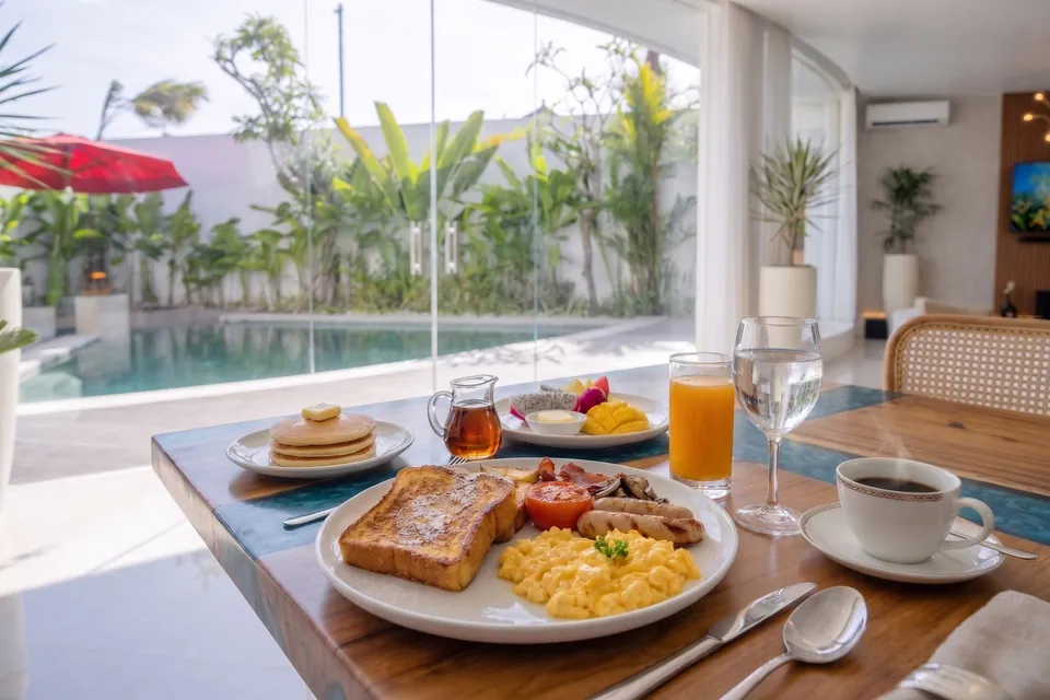 Continental breakfast: French toast, scrambled eggs, bacon, sausage and grilled tomato, with pancakes, fruit, orange juice and coffee