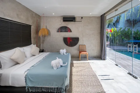 A bedroom at Concrete Serenity with floor-to-ceiling windows beside the pool