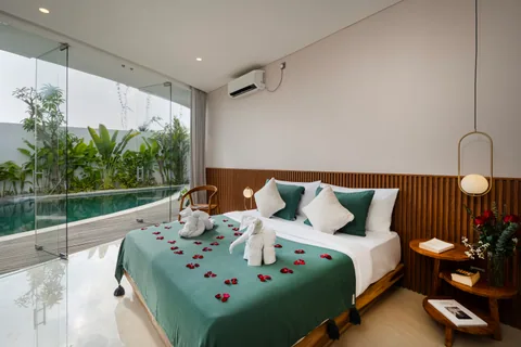 Villa Soluna's pool-facing bedroom, photographed with decorative towels and petals