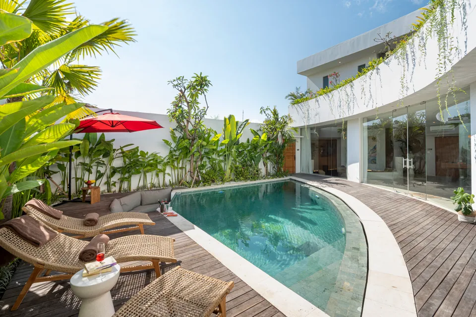 Villa Soluna's pool terrace, sun loungers and curved façade